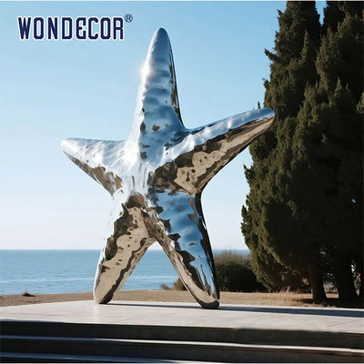 Large stainless steel star shaped outdoor sculpture in the park